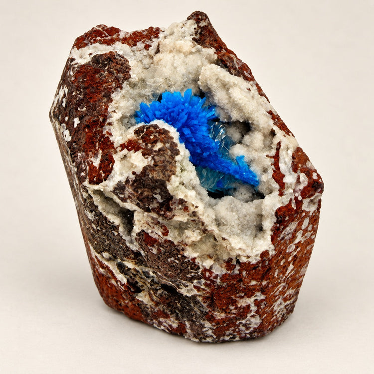 Natural Cavansite crystal specimen with vivid blue crystal formations on a white and reddish-brown matrix