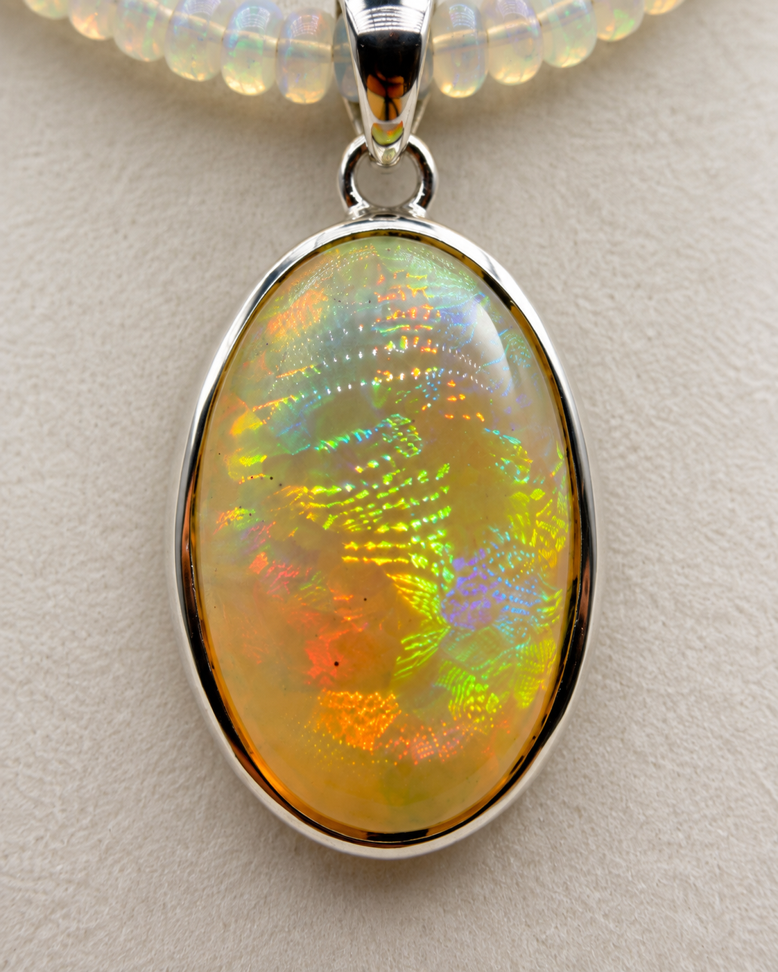 27ct Ethiopian opal pendant in sterling silver showing green orange red and violet play-of-color