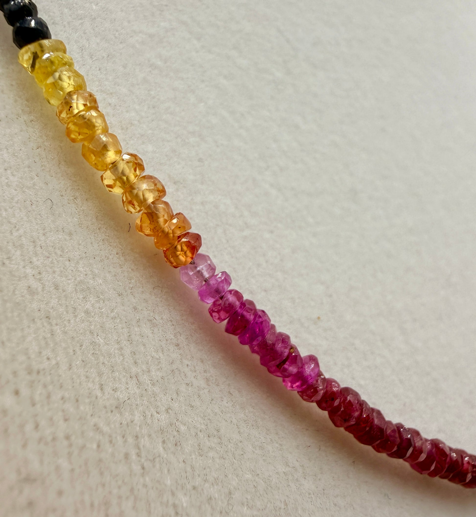 Close-up of multicolor sapphire and emerald gemstone necklace