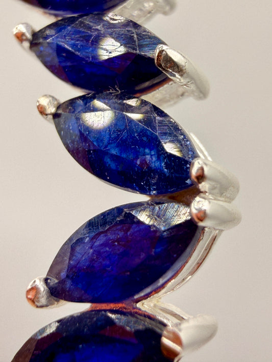 Close-up of deep blue Ceylon sapphire gemstones in sterling silver