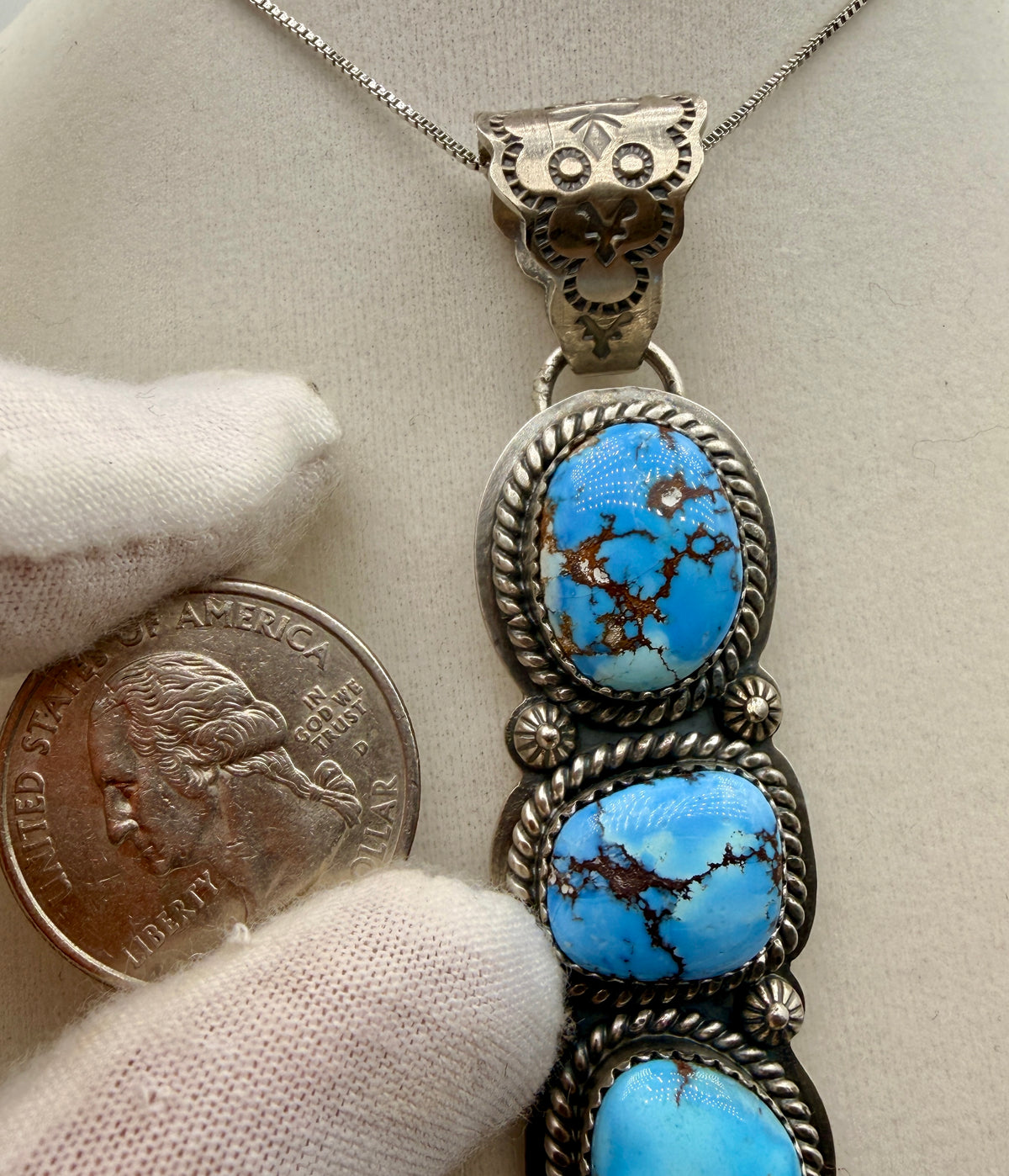 Three-stone Golden Hills turquoise pendant shown beside a quarter for scale