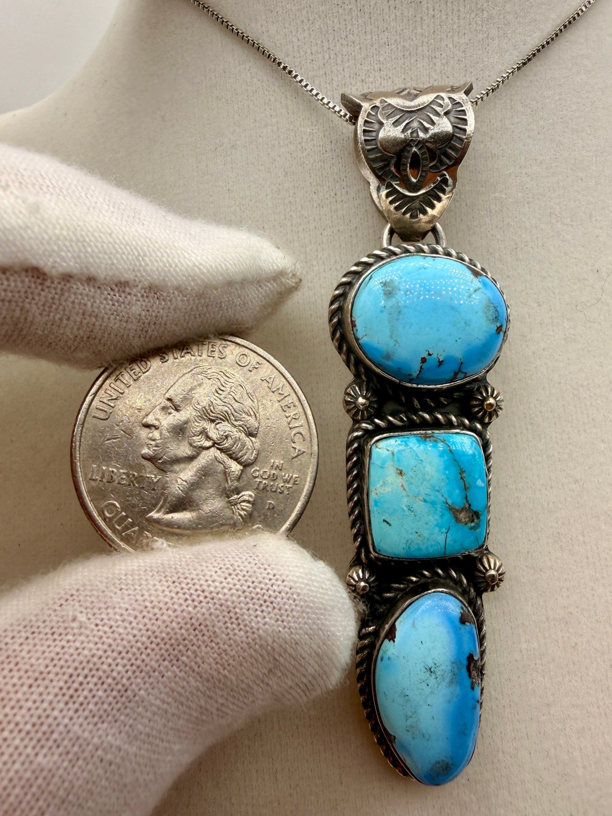 Golden Hills turquoise three-stone pendant shown beside a quarter for scale