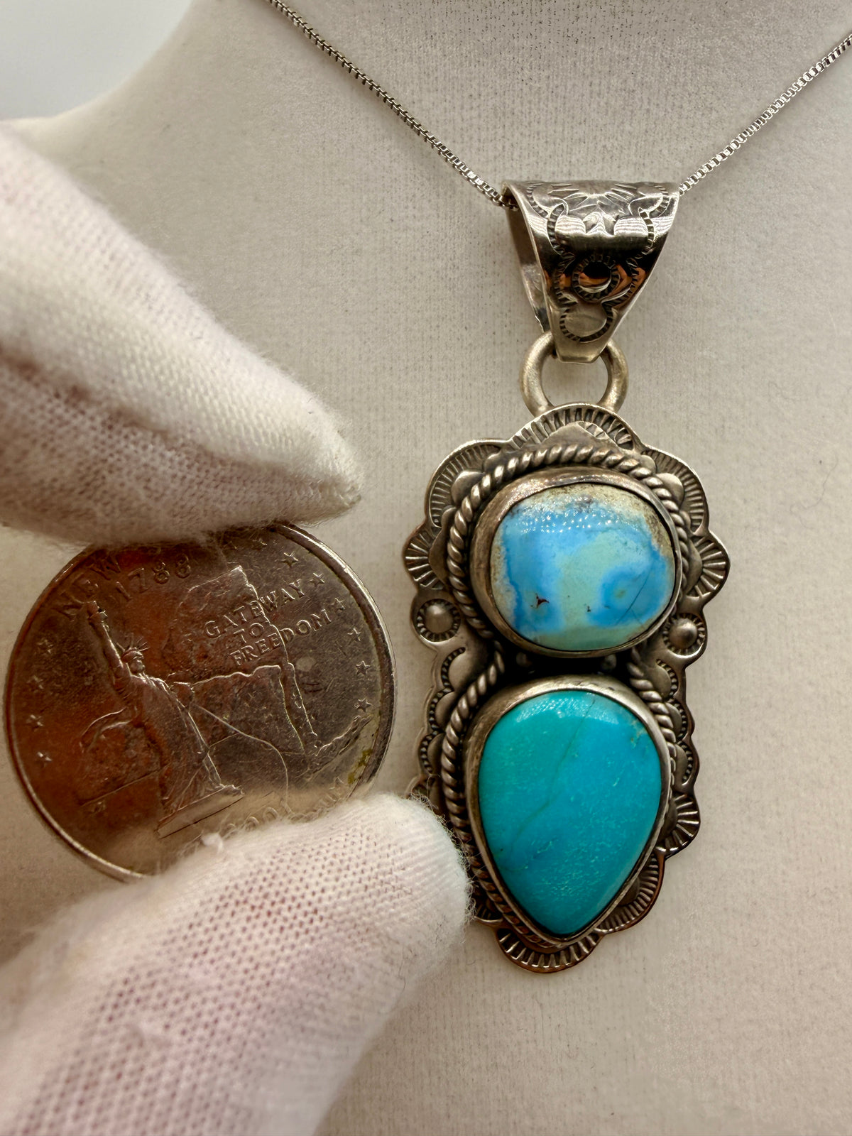 ZIA Golden Hills and Tyrone turquoise pendant displayed beside a quarter for scale
