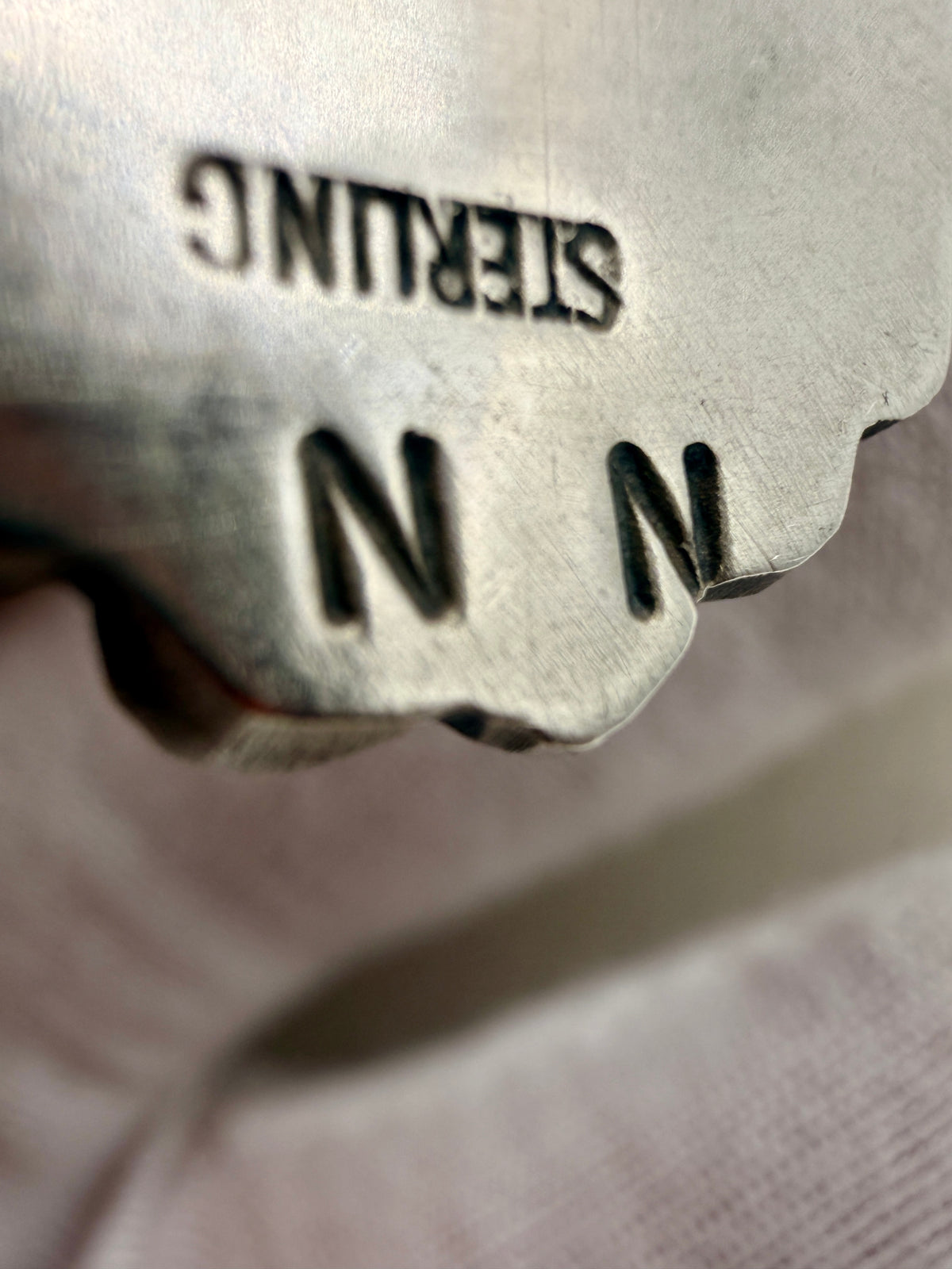 N N artist hallmark and Sterling stamp on the back of the turquoise pendant