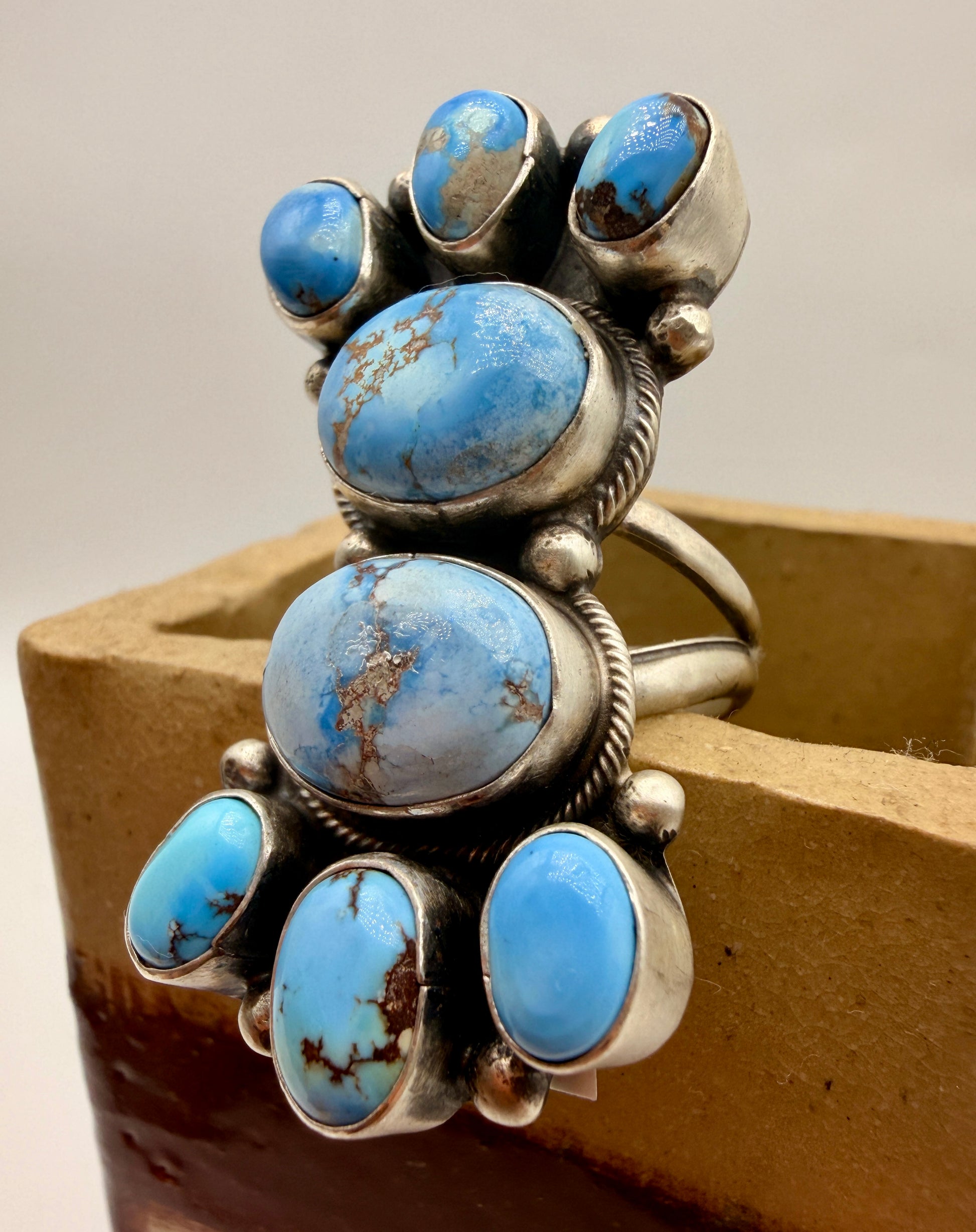 Side view showing raised Golden Hills turquoise cabochons and twisted sterling silver borders