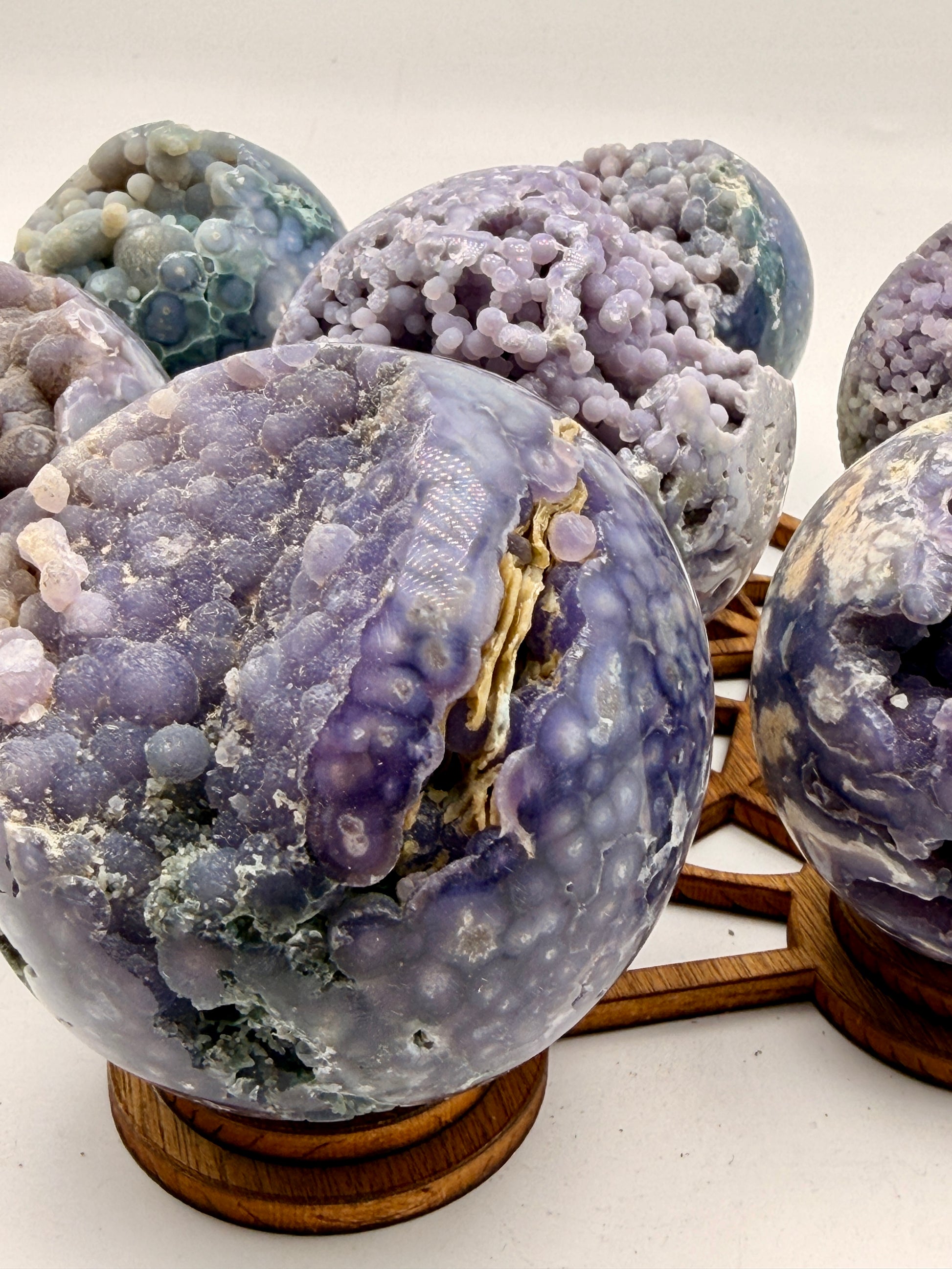 Natural Grape Agate sphere from Indonesia featuring lavender botryoidal chalcedony, exposed druzy crystal cavities, and polished collector-quality finish.
