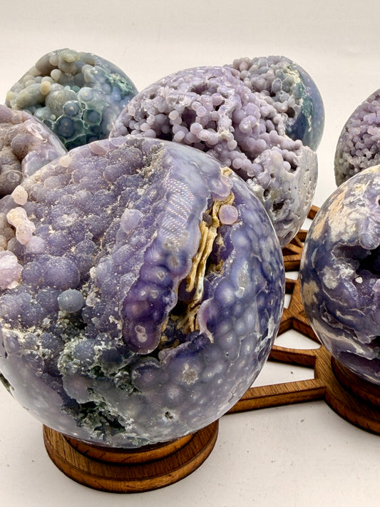 Natural Grape Agate sphere from Indonesia featuring lavender botryoidal chalcedony, exposed druzy crystal cavities, and polished collector-quality finish.