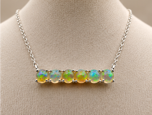 Natural seven-stone opal sterling silver bar necklace showing green blue violet and golden play-of-color