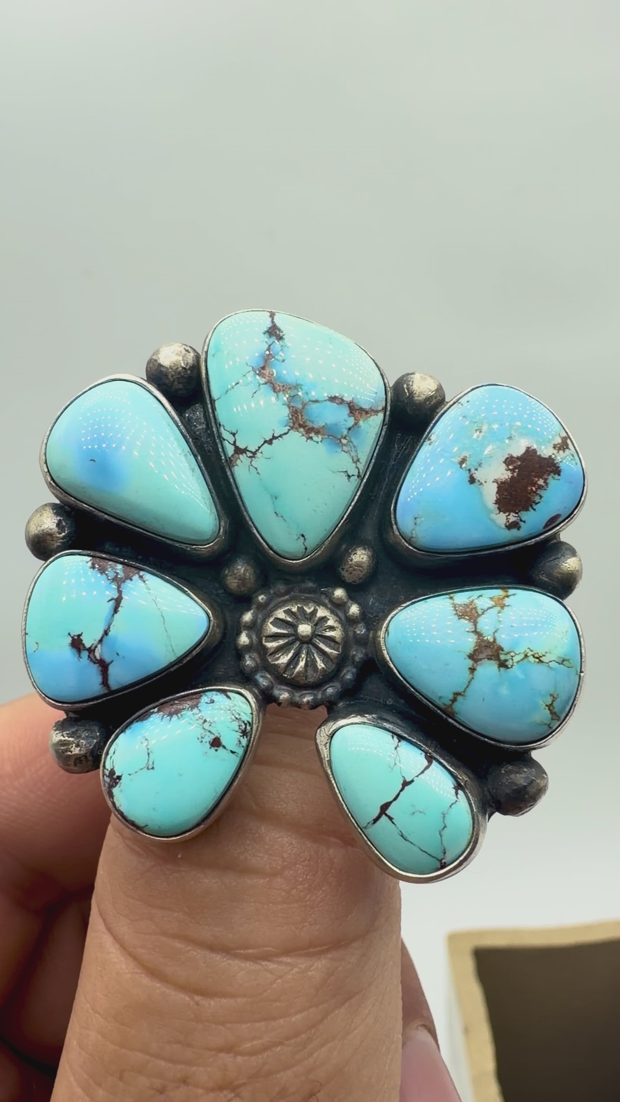 Video showing the Golden Hills turquoise stones, sterling silver cluster setting and adjustable band of a Travis Jim ring