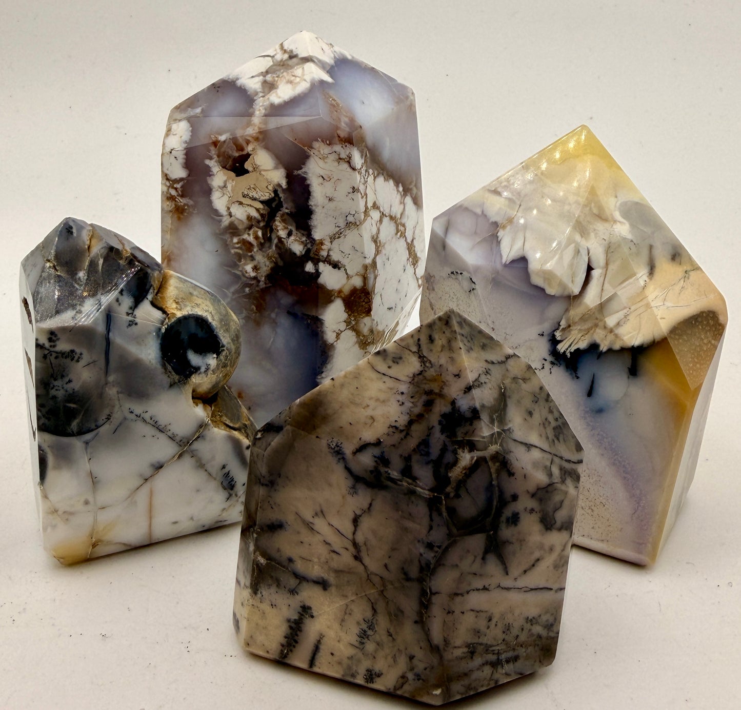 Natural Purple Dendritic Opal crystal towers featuring lavender opal, black dendritic inclusions, and polished collector-quality points, commonly known as Merlinite.